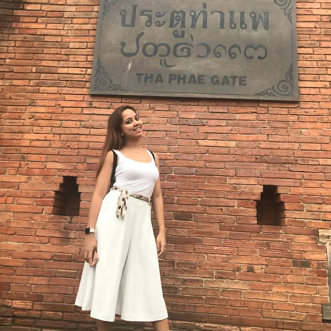 Dee in white in front of the brick Tha Phae Gate