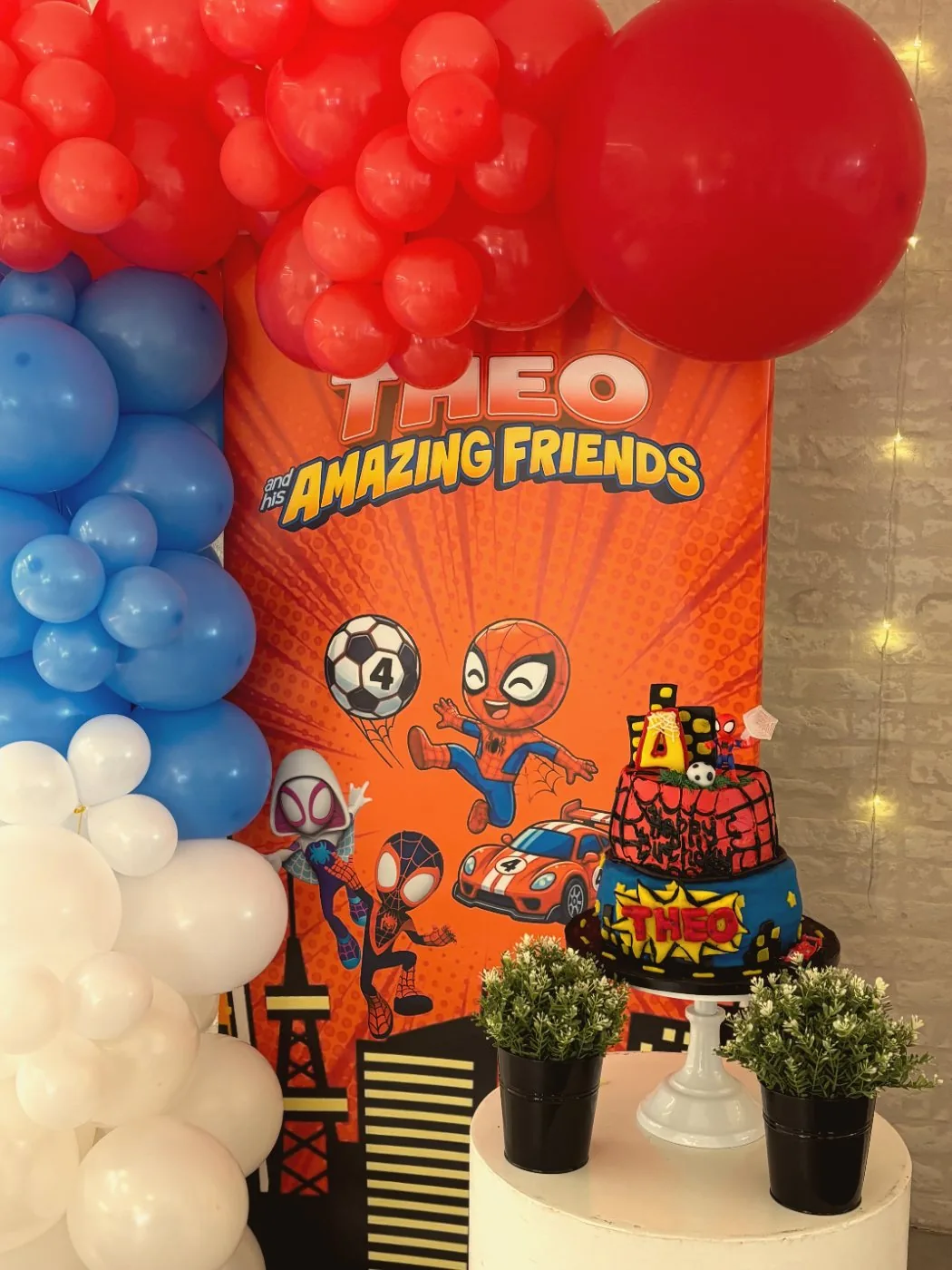 Red, blue and white balloon garland beside the cake