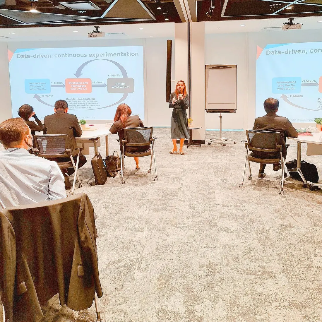 Dee presenting a workshop on data-driven, continuous experimentation to a room of seated colleagues